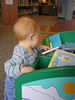 jasonandbecky > We went to the Brookline Library on Thursday, and at 1 p.m. had the place to ourselves.  We discovered this bin of board books, and Nick gravitated to the Planes book he has at home.  He's pointing to the crop duster here.
